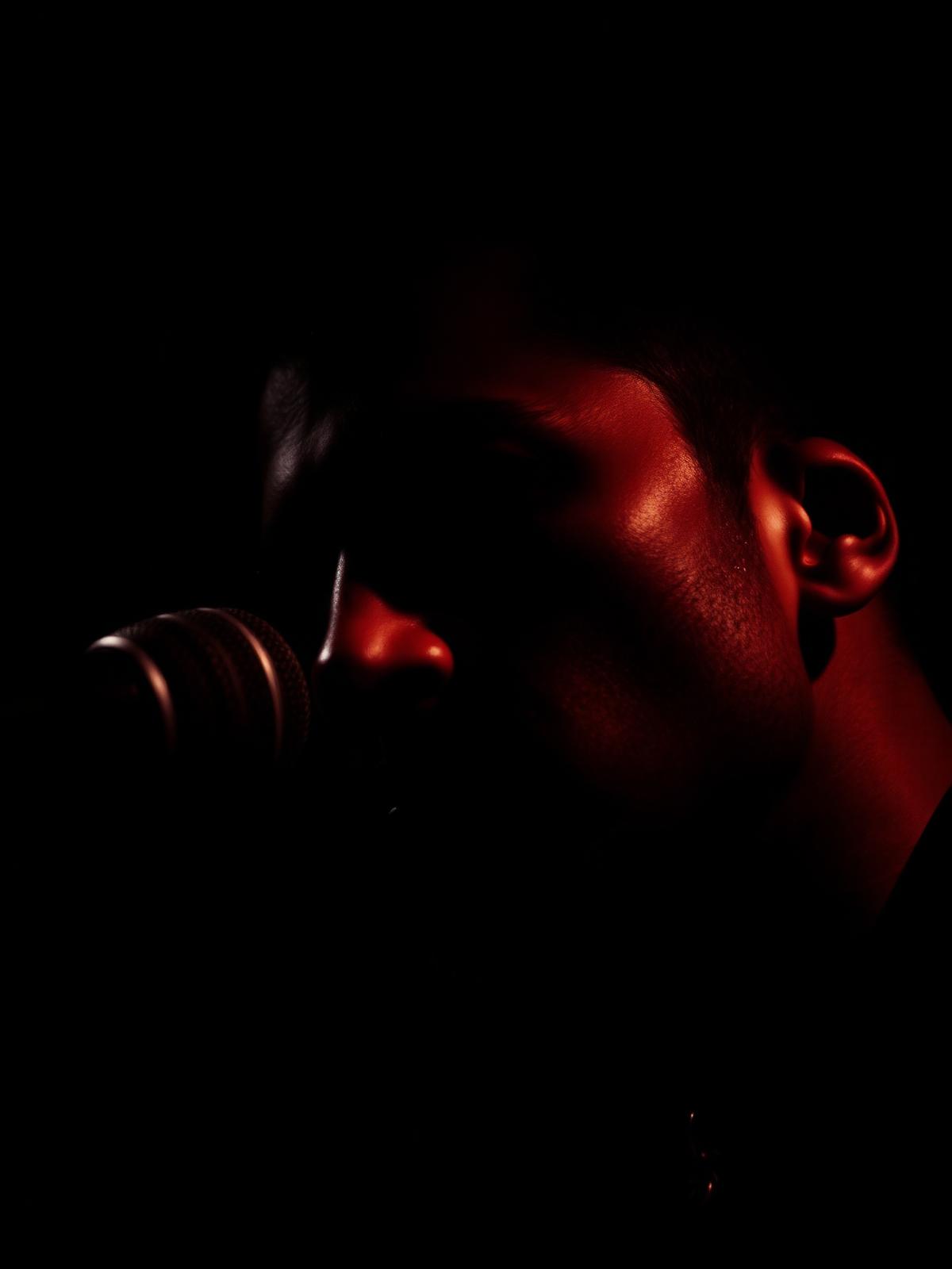 Portrait rapproché d'un chanteur au micro en lumière rouge
